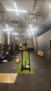 Functional training zone at Torque Fitness with kettlebells, tires, monkey bars, sled push equipment, dip station, and strength training tools